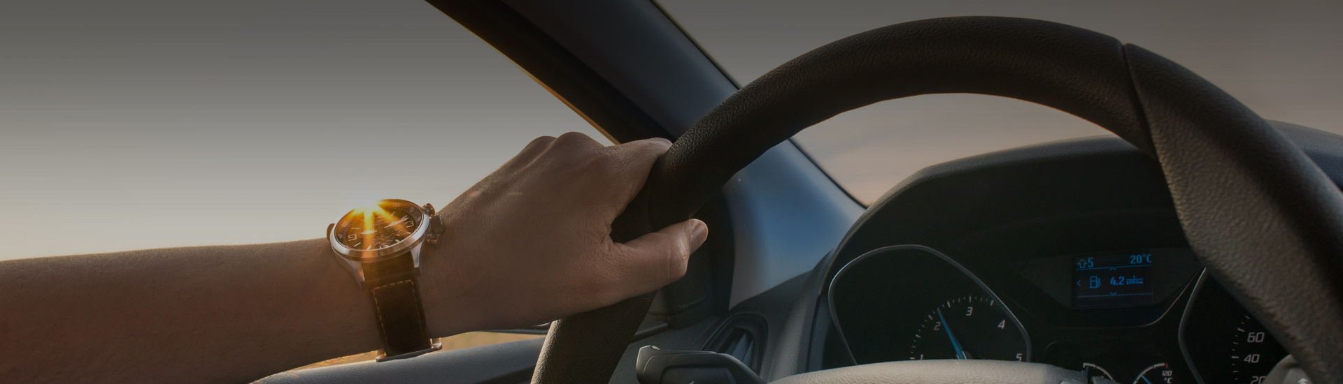 Photo of a man holding a steering wheel
