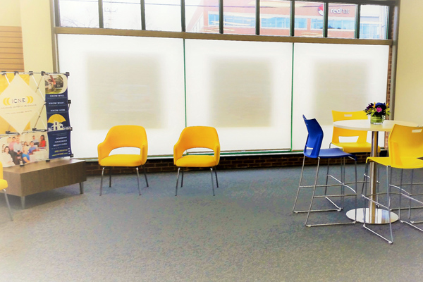Photo of a waiting area with yellow and blue chairs