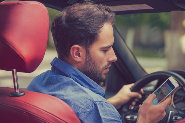 Photo of a man being distracted while driving