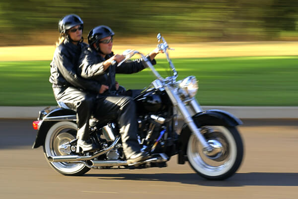 Photo of a couple riding on a motorcycle together