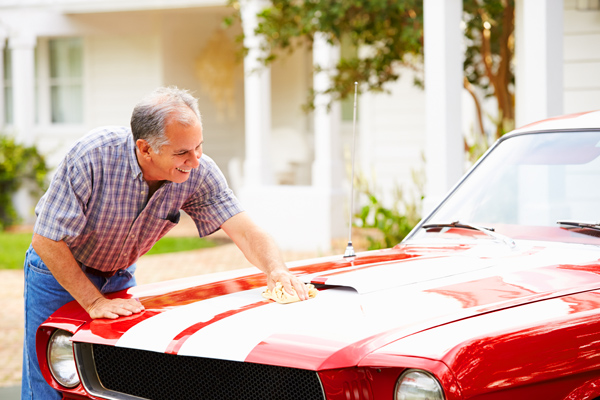 Photo of a man waxing his collectors car - Links to Collector Car Insurance page