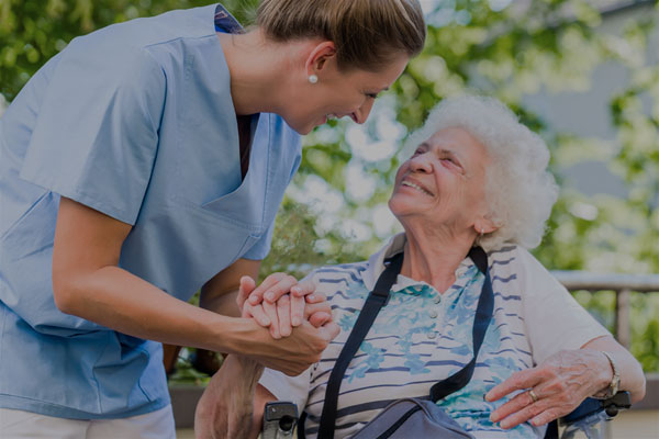 A caregiver and an elderly patient - Links to Business Specialty Insurance page