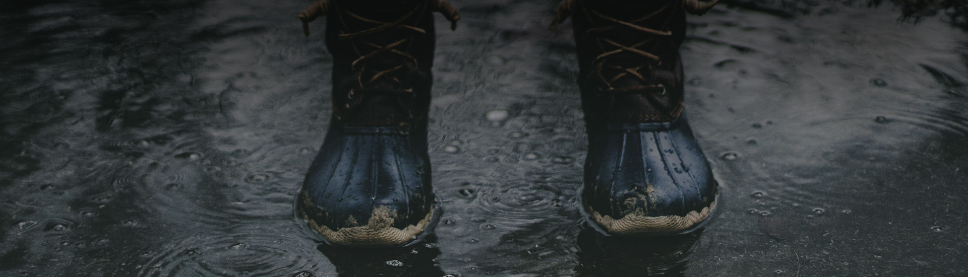 Decorative image of a photo of a pair of boots in a large puddle of water