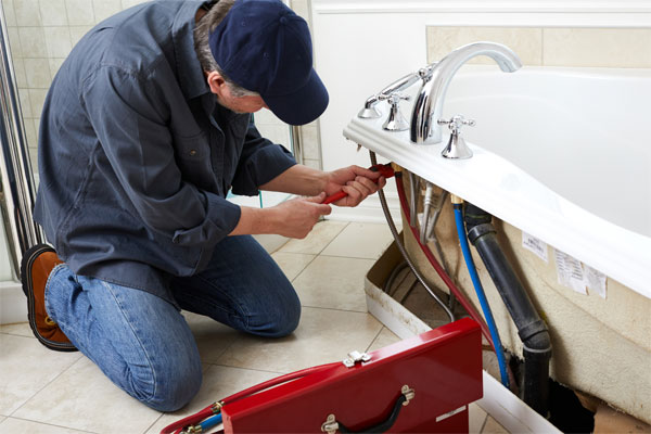 A photo of a plumber fixing a sink for a homeowners insurance claim